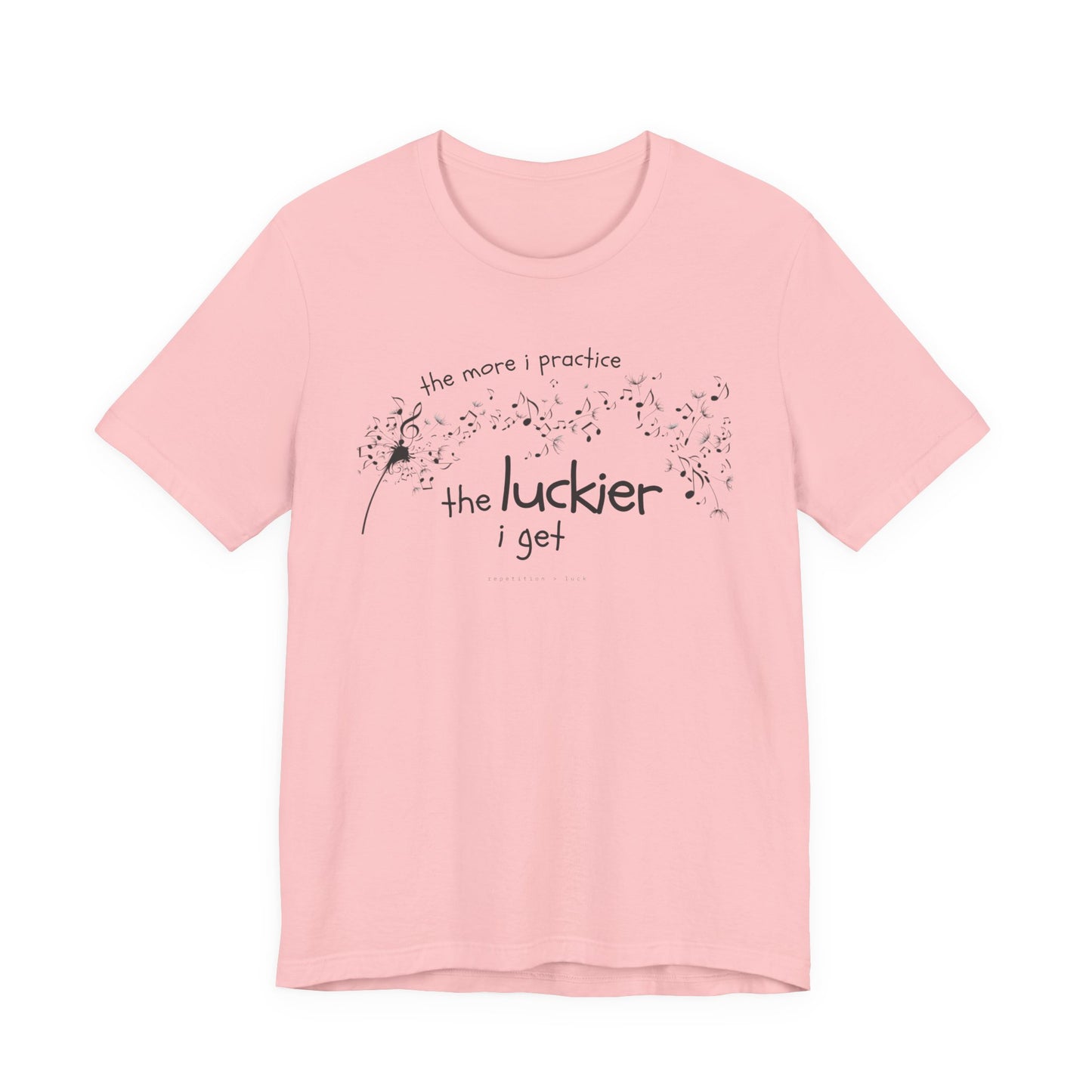 Front view of a pink Bella Canvas t-shirt with a clever music-themed graphic. The design shows a stylized guitar headstock and musical notes above text that reads: ‘The more I practice, the luckier I get.’ Soft 100% cotton shirt perfect for musicians and music teachers.