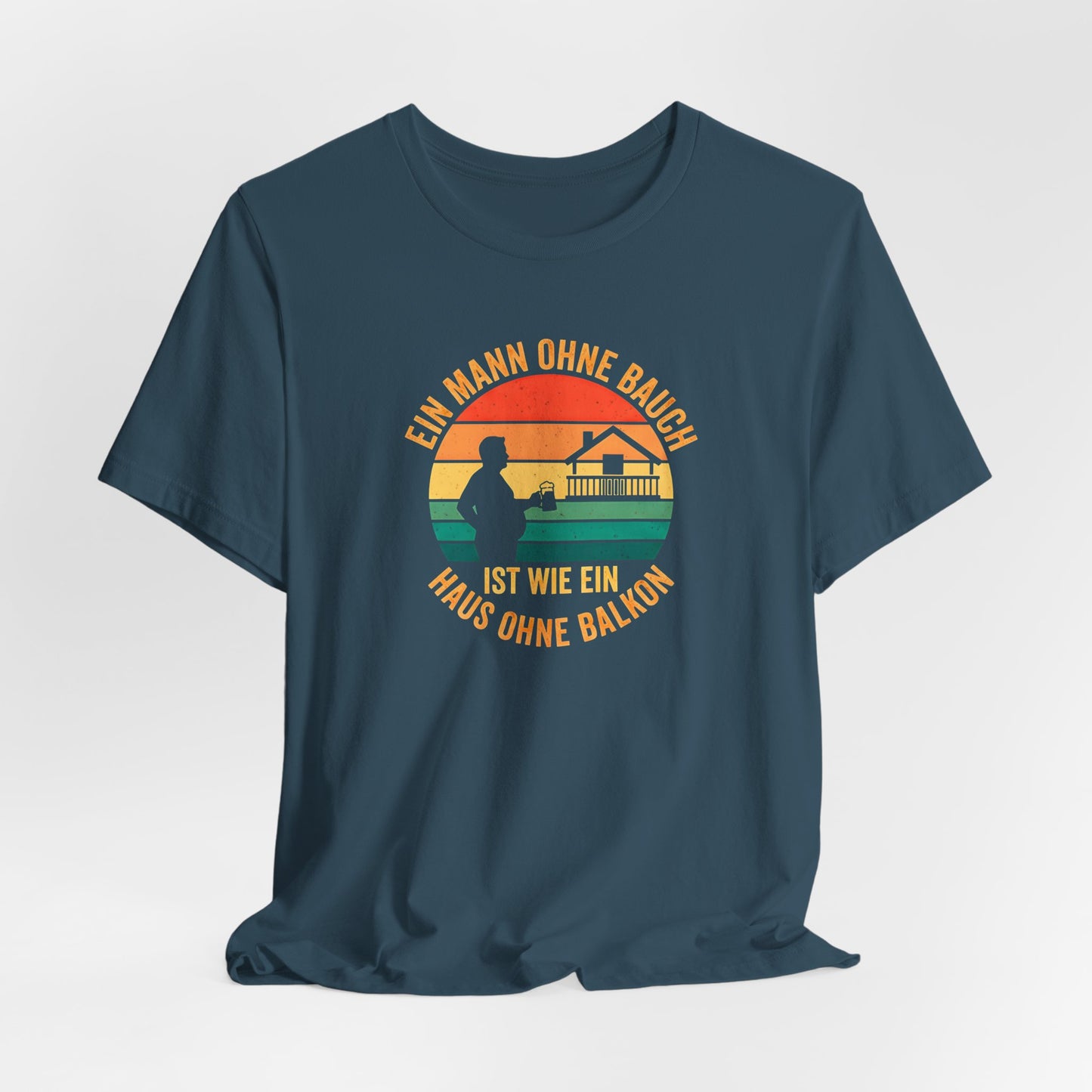 Nahaufnahme des hochwertigen Textildrucks auf dem blauen T-Shirt. Das runde Retro-Design zeigt die Silhouette eines Mannes mit Bierkrug neben einem Haus mit prominentem Balkon vor einem gestreiften Sonnenuntergang. Der Text "EIN MANN OHNE BAUCH IST WIE EIN HAUS OHNE BALKON" umrahmt das Motiv in einer Vintage-Schriftart. Der Druck ist scharf, die Farben sind deckend, aber nicht gummiartig, was auf eine hohe Qualität hindeutet. Man erkennt die weiche Textur der Baumwolle des Bella Canvas 3001 Shirts.