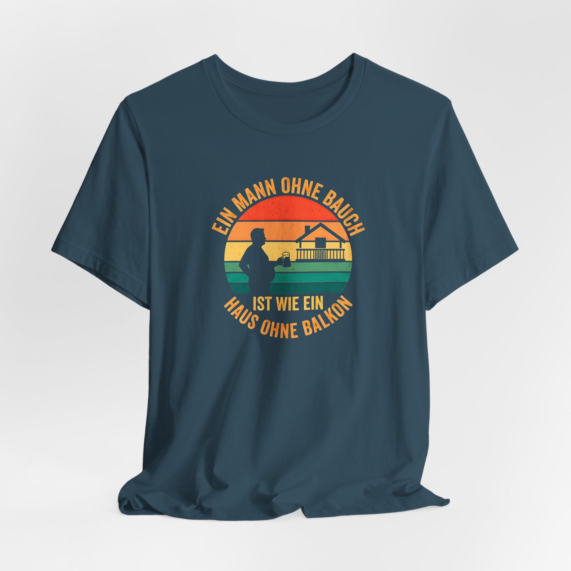 Nahaufnahme des hochwertigen Textildrucks auf dem blauen T-Shirt. Das runde Retro-Design zeigt die Silhouette eines Mannes mit Bierkrug neben einem Haus mit prominentem Balkon vor einem gestreiften Sonnenuntergang. Der Text "EIN MANN OHNE BAUCH IST WIE EIN HAUS OHNE BALKON" umrahmt das Motiv in einer Vintage-Schriftart. Der Druck ist scharf, die Farben sind deckend, aber nicht gummiartig, was auf eine hohe Qualität hindeutet. Man erkennt die weiche Textur der Baumwolle des Bella Canvas 3001 Shirts.