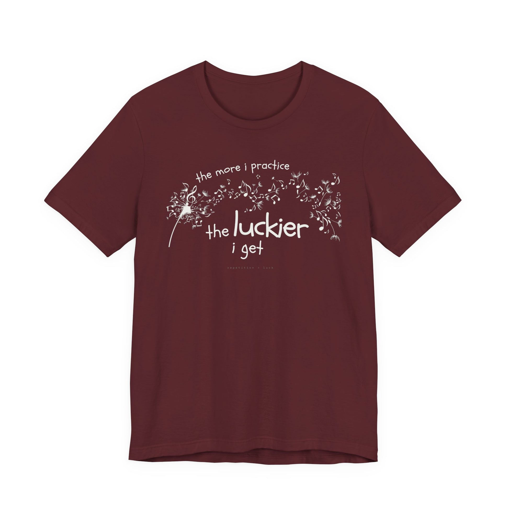 Front view of a maroon Bella Canvas t-shirt with a clever music-themed graphic. The design shows a stylized guitar headstock and musical notes above text that reads: ‘The more I practice, the luckier I get.’ Soft 100% cotton shirt perfect for musicians and music teachers.