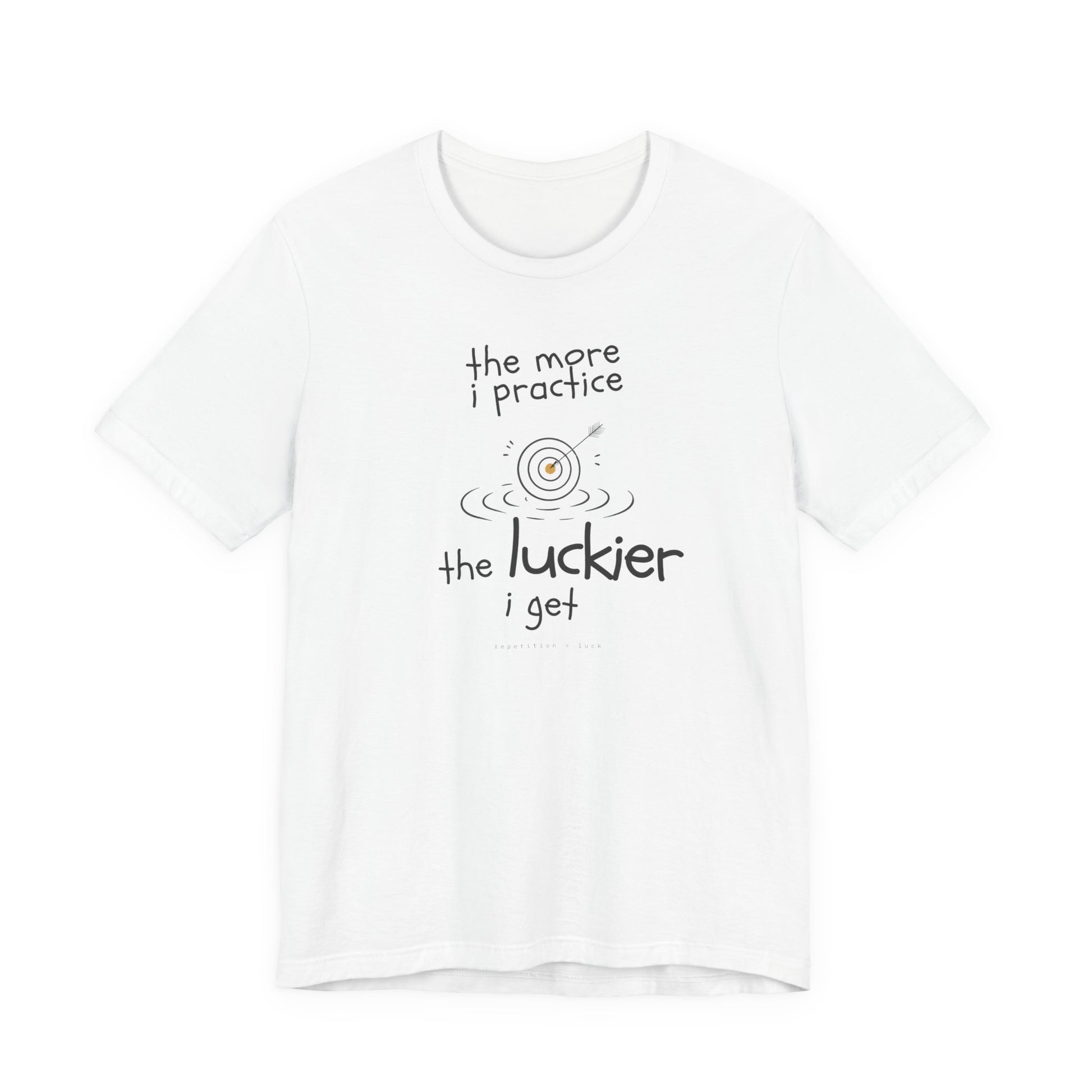 Minimalist motivational T-shirt design shown on a white shirt: hand-drawn cream lettering reads “the more i practice” above a sketched bullseye with an arrow and small mustard center, ripple lines underneath, then larger text reads “the luckier i get” with tiny mono text below that says “repetition > luck.”