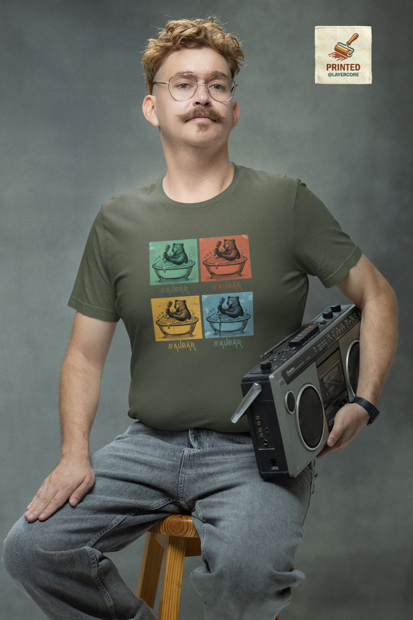 Vintage-Illustration eines Bären in einer Badewanne mit dem Schriftzug Saubär auf einem grünem T-Shirt welches von einem jungen Mann im vintage look getragen wird