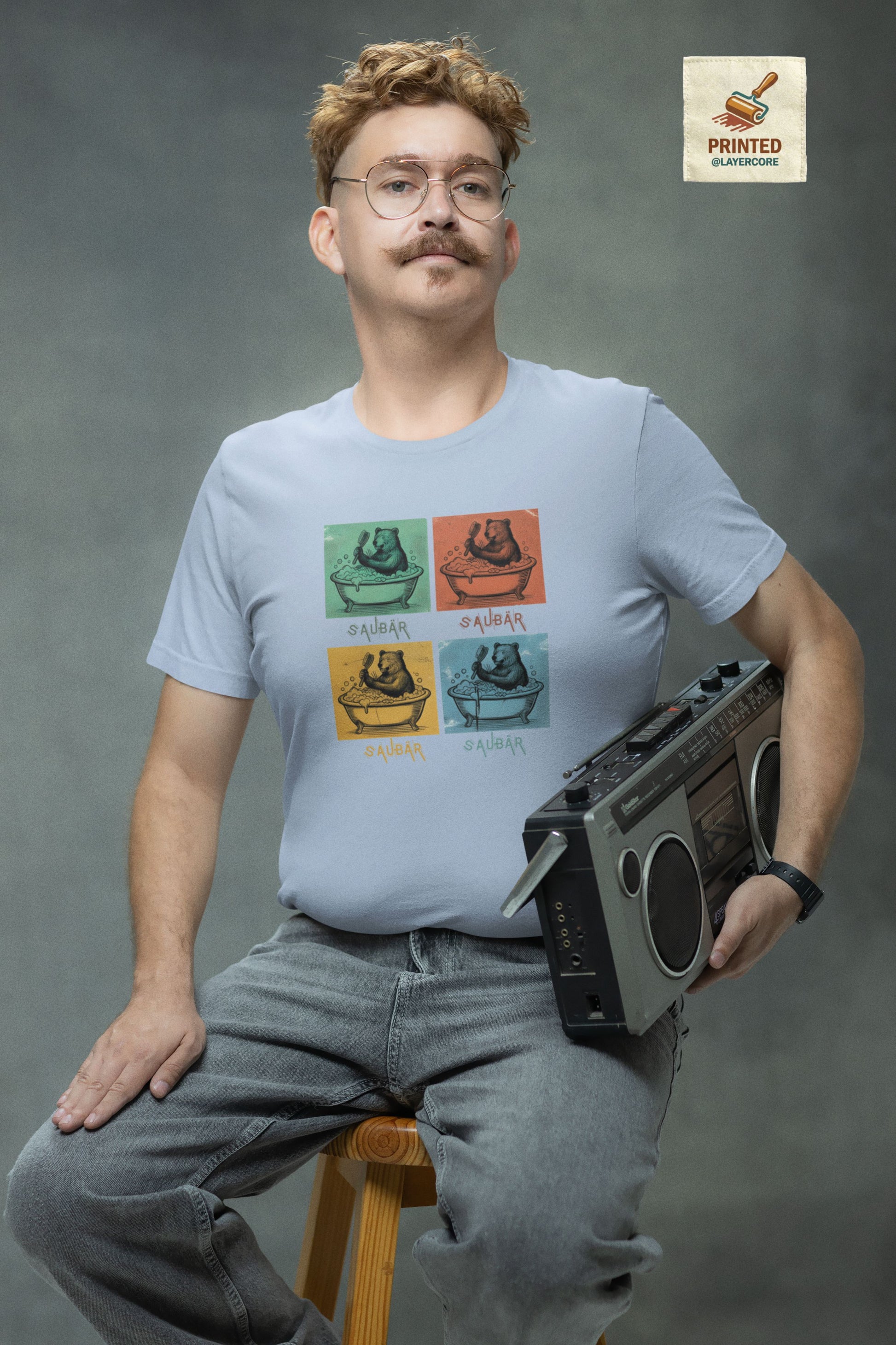 Vintage-Illustration eines Bären in einer Badewanne mit dem Schriftzug Saubär auf einem hellblauem T-Shirt welches von einem jungen Mann im vintage look getragen wird