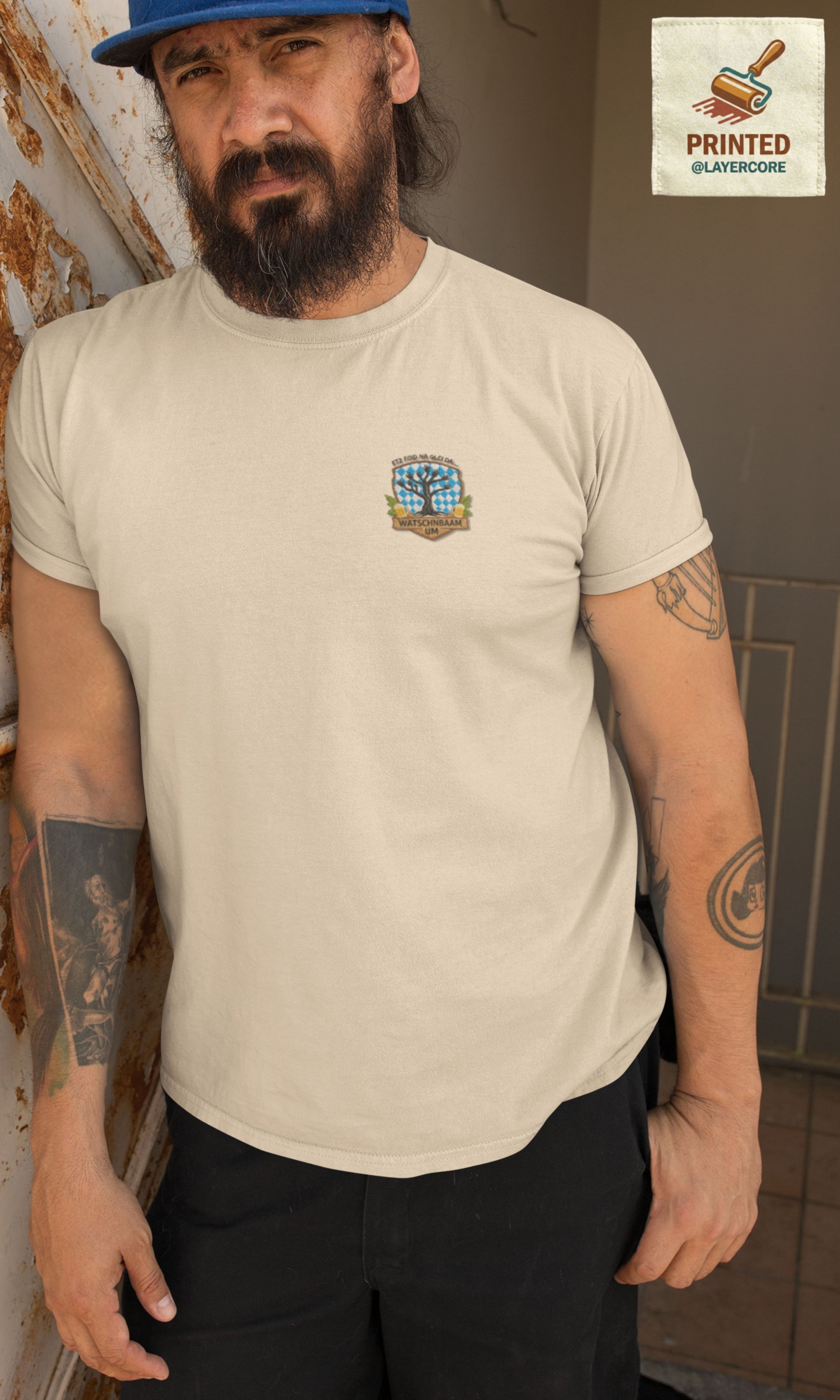 Watschnbaam natural farbenes T-Shirt in Stick-Optik (Druck), bayerisches Wappen mit Händen als Äste, Bierkrügen und Hopfen. Mann mittleren Alters mit Bart und Tattoos trägt das Shirt