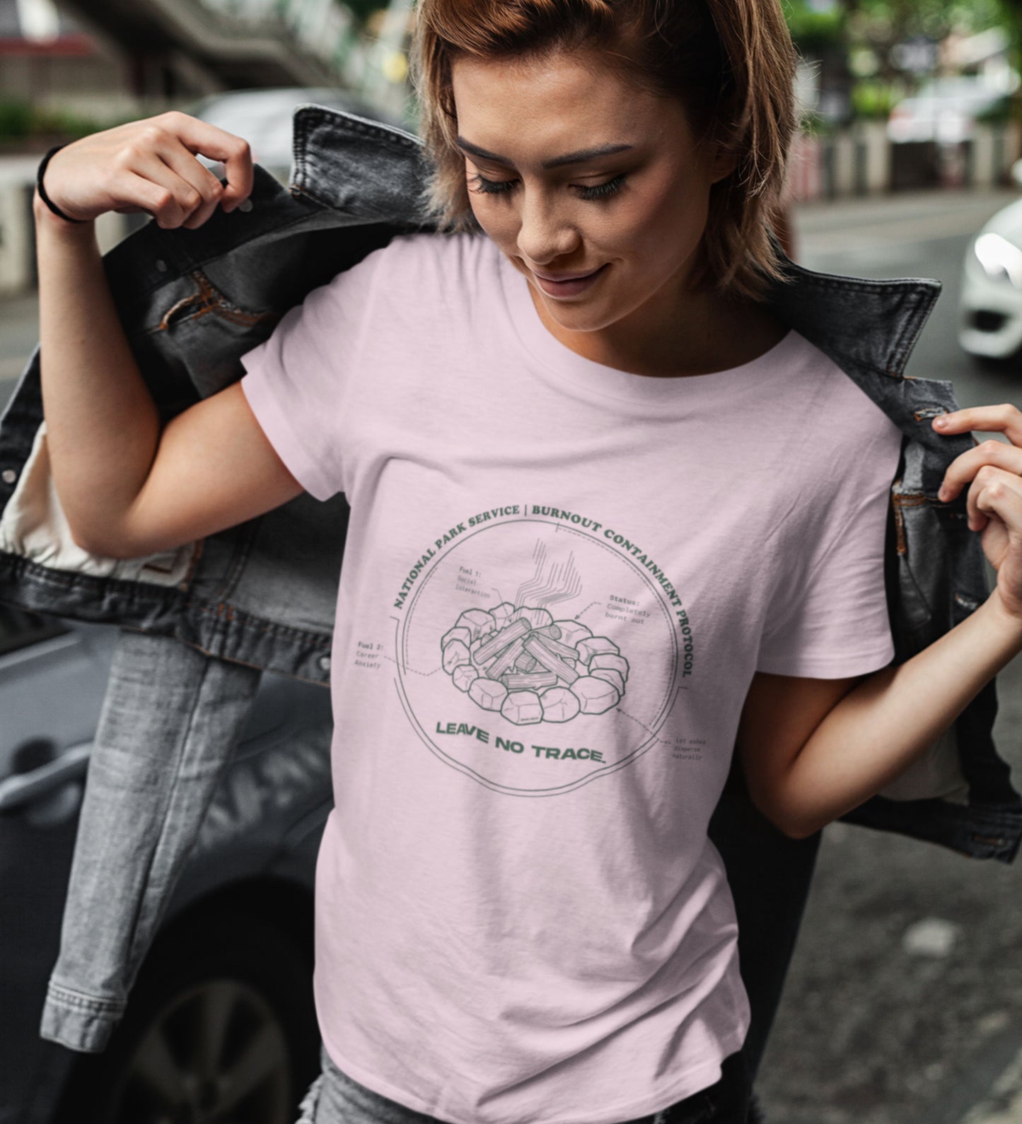 Technisches Diagramm eines Lagerfeuers mit Text Burnout Containment Protocol auf pinkem T-Shirt, getragen von einer jungen Faru mit Lederjacke. Anti-Gorpcore Streetwear.