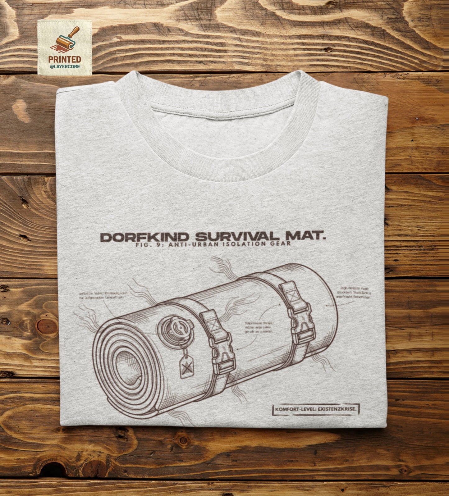 Technische Blueprint-Zeichnung einer Isomatte mit ironischen Texten zum Dorfleben auf einem sch farbenem T-Shirt. Anti-Gorpcore Design.