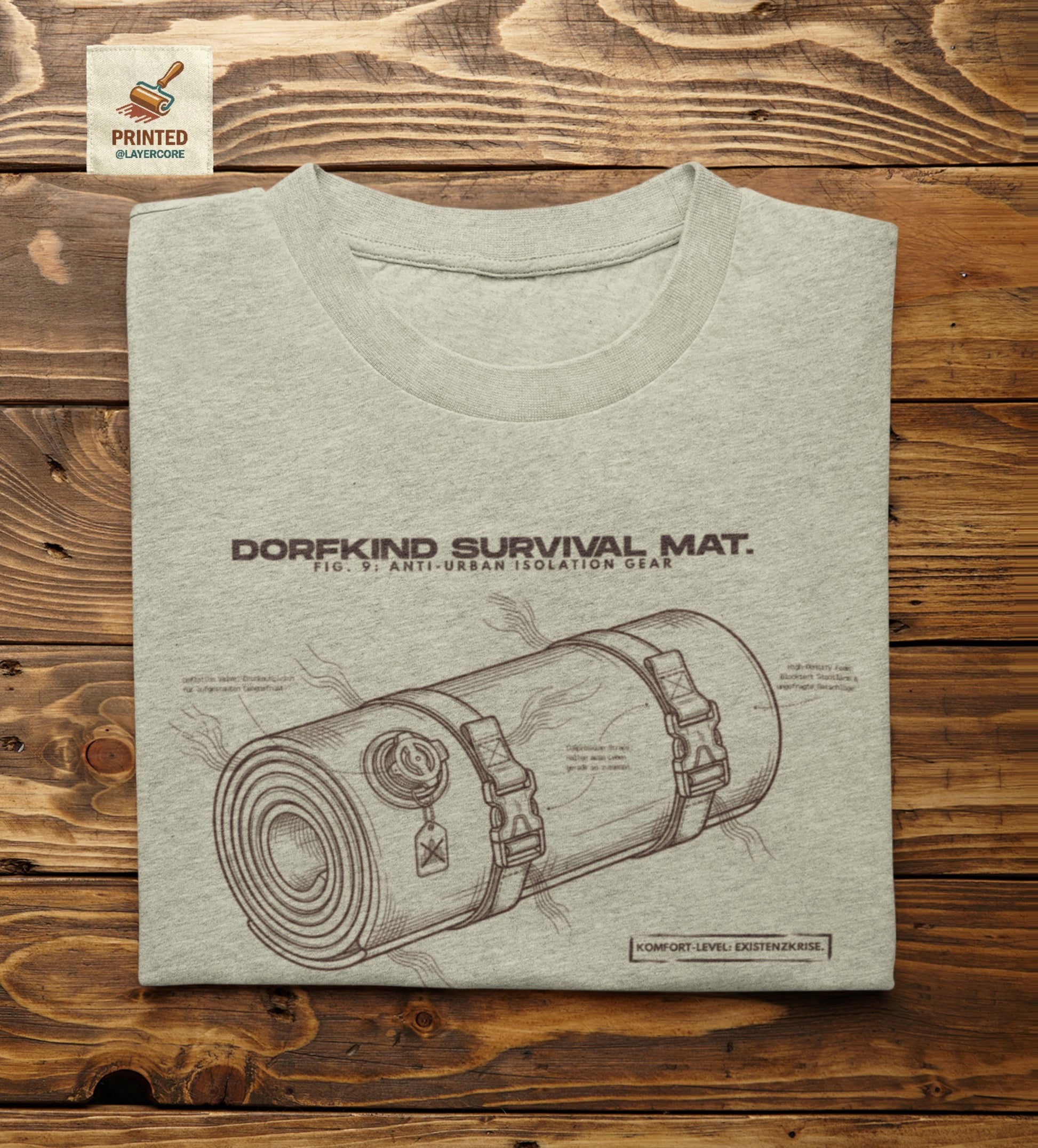 Technische Blueprint-Zeichnung einer Isomatte mit ironischen Texten zum Dorfleben auf einem natural farbenem T-Shirt. Anti-Gorpcore Design.