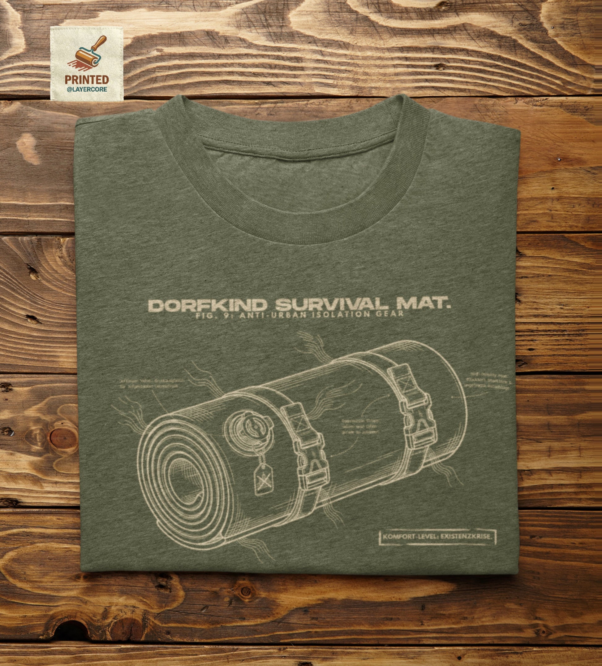 Technische Blueprint-Zeichnung einer Isomatte mit ironischen Texten zum Dorfleben auf einem military grünem T-Shirt. Anti-Gorpcore Design.