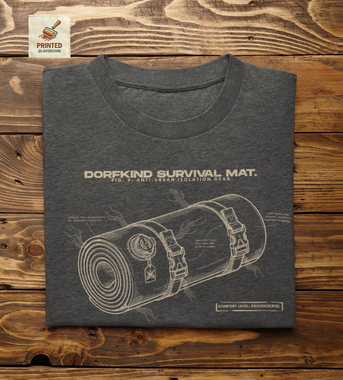 Technische Blueprint-Zeichnung einer Isomatte mit ironischen Texten zum Dorfleben auf einem dark heather farbenem T-Shirt. Anti-Gorpcore Design.