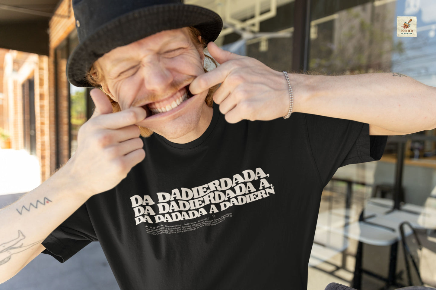 Da dadierdada schwarzes T-Shirt. Bayerischer Zungenbrecher und Wortwitz im todernsten Lexikon-Design. Schweres Gildan 5000 Baumwollshirt, getragen von einem jungen Mann.