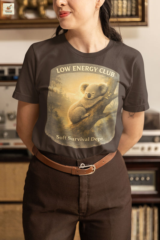 low energy club koala brown shirt calm aesthetic vintage design, worn by a woman standing in an antique shop