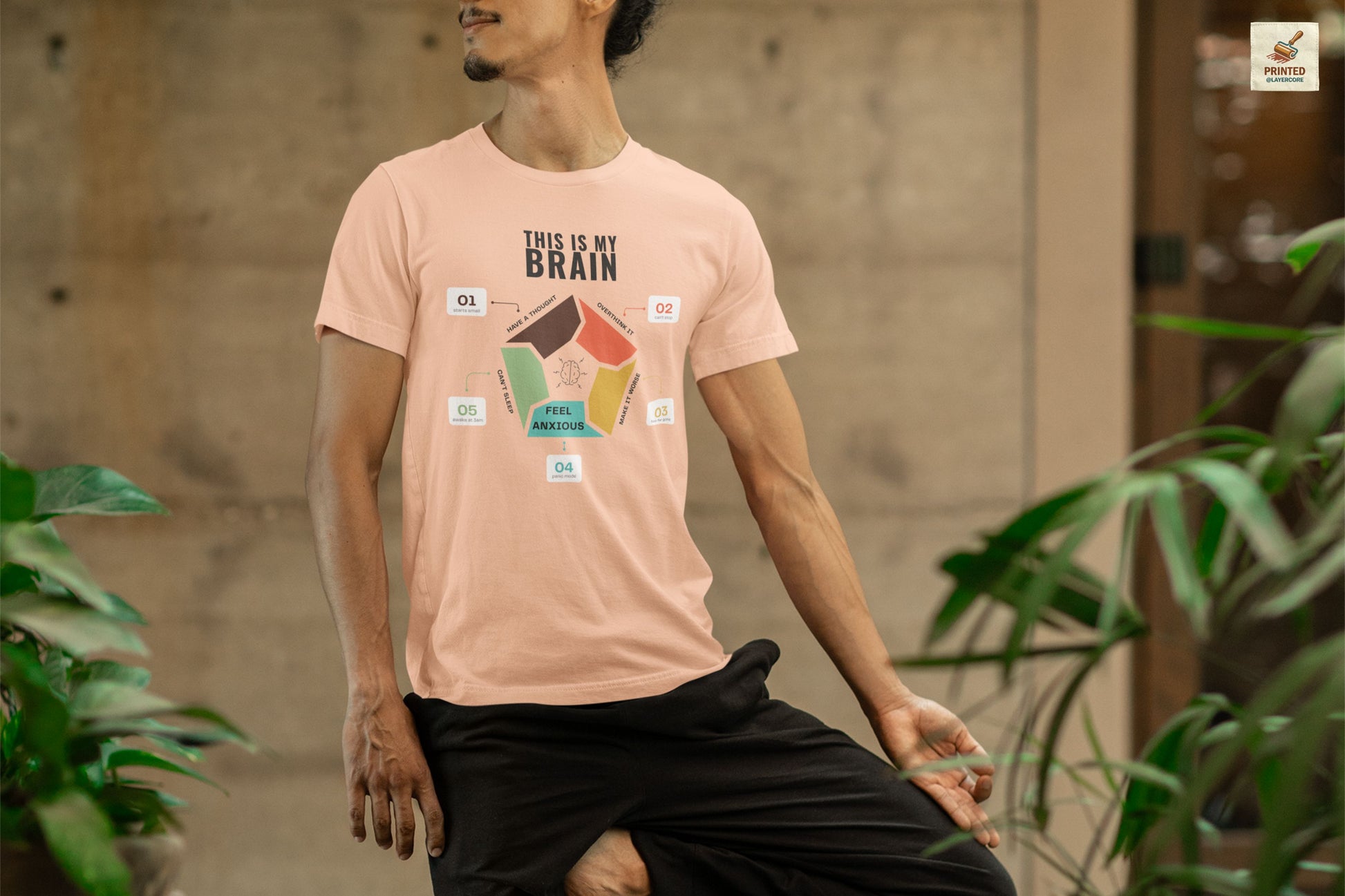 Minimalist peach coloured t-shirt showing a structured overthinking cycle with segmented diagram and clean typography, representing anxiety, sleeplessness, and mental loops in a subtle and modern visual style, worn by a young man