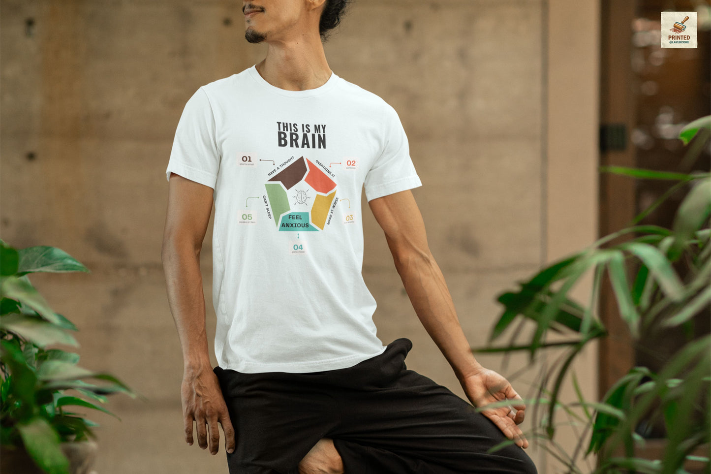Minimalist heather ice coloured t-shirt showing a structured overthinking cycle with segmented diagram and clean typography, representing anxiety, sleeplessness, and mental loops in a subtle and modern visual style, worn by a young man