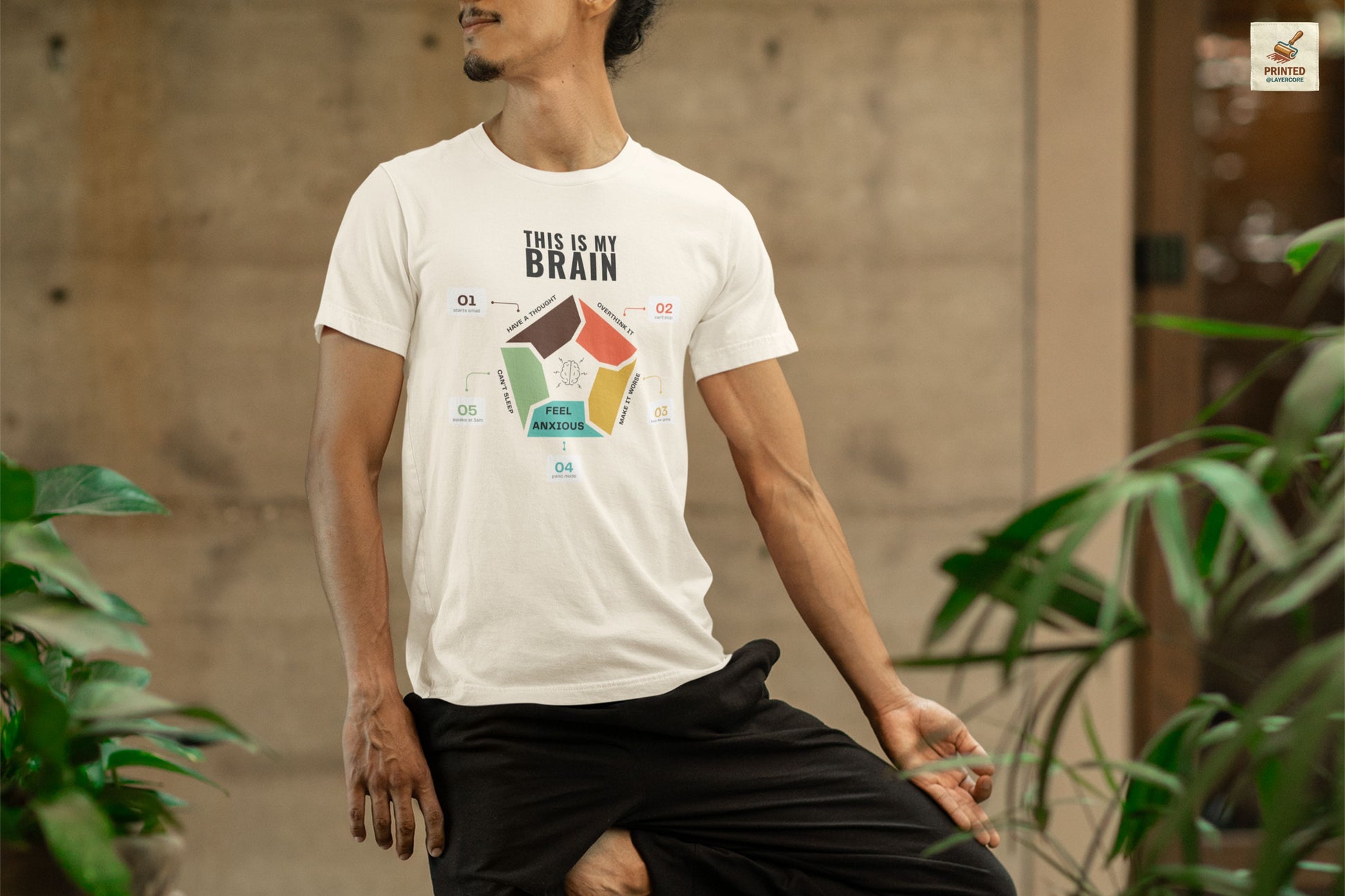 Minimalist natural coloured t-shirt showing a structured overthinking cycle with segmented diagram and clean typography, representing anxiety, sleeplessness, and mental loops in a subtle and modern visual style, worn by a young man