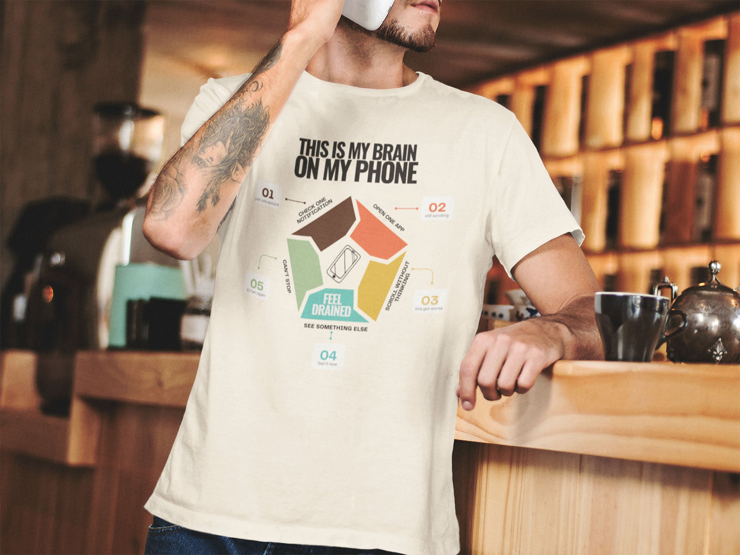 Minimalist doomscrolling cycle t-shirt natural coloured, design reading “This Is My Brain on My Phone” with screen time steps and “Feel Drained” center worn by a young man