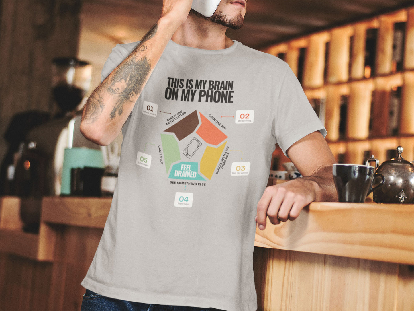 Minimalist doomscrolling cycle t-shirt ingrey, design reading “This Is My Brain on My Phone” with screen time steps and “Feel Drained” center worn by a young man