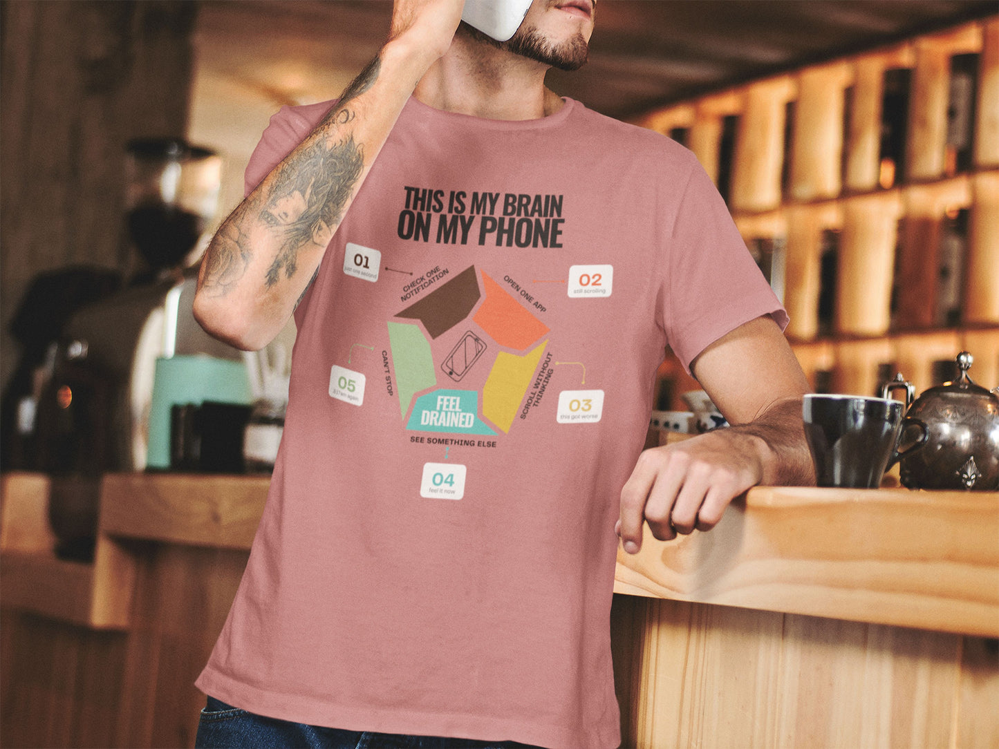 Minimalist doomscrolling cycle t-shirt  in mauve, design reading “This Is My Brain on My Phone” with screen time steps and “Feel Drained” center worn by a young man