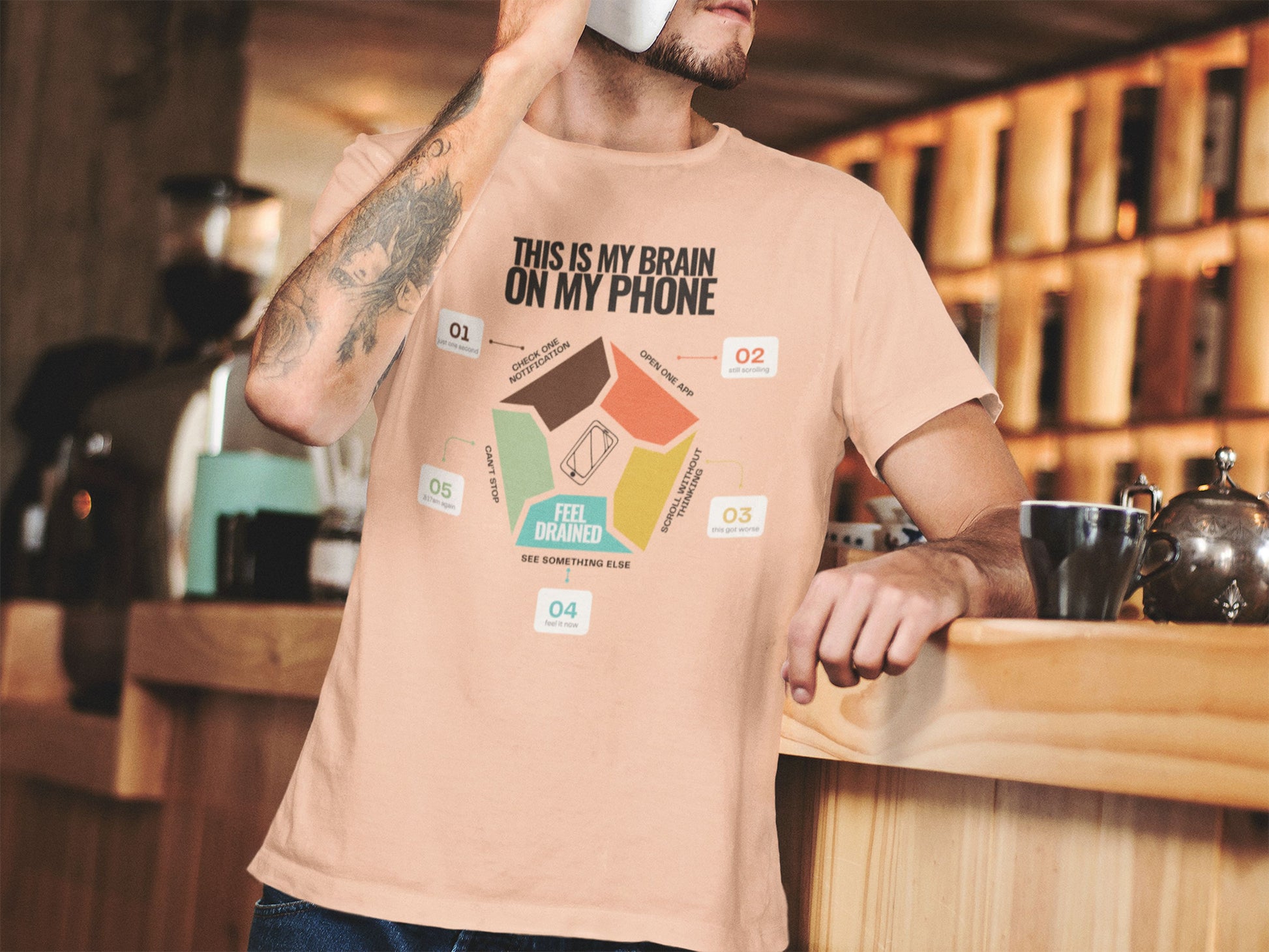 Minimalist doomscrolling cycle t-shirt  in peach, design reading “This Is My Brain on My Phone” with screen time steps and “Feel Drained” center worn by a young man