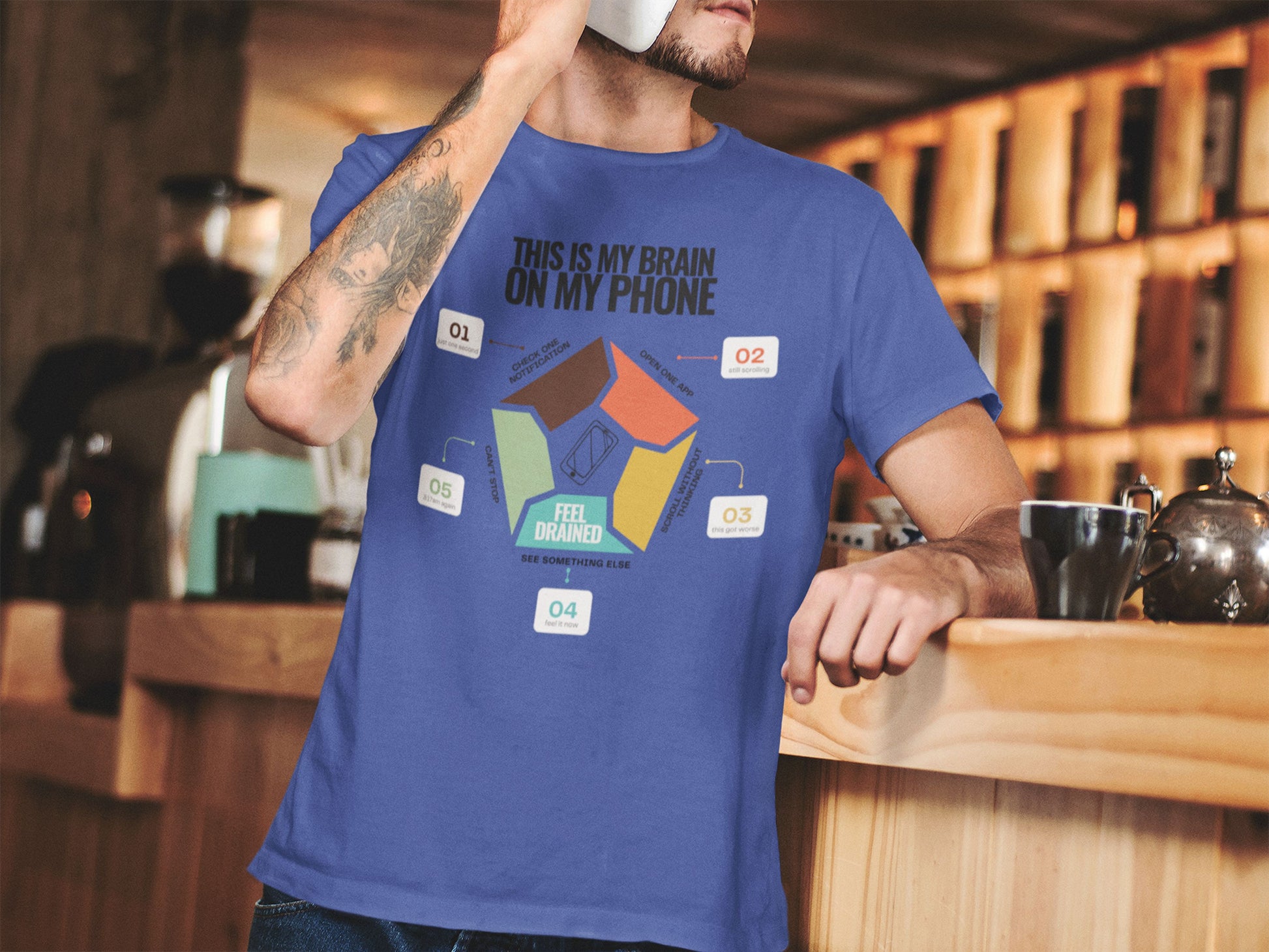 Minimalist doomscrolling cycle t-shirt in blue, design reading “This Is My Brain on My Phone” with screen time steps and “Feel Drained” center worn by a young man