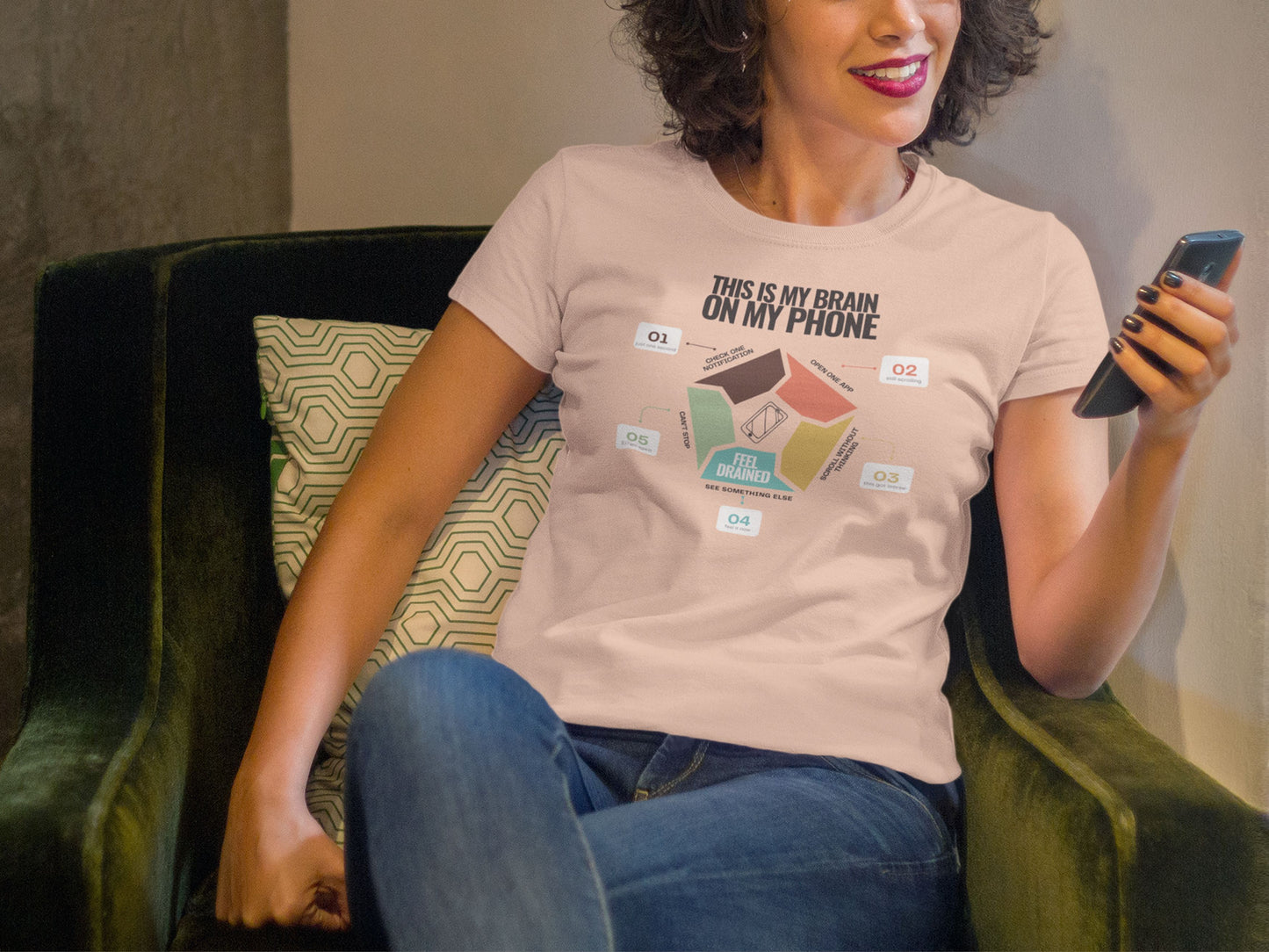 Minimalist doomscrolling cycle t-shirt  in peach coloured, design reading “This Is My Brain on My Phone” with screen time steps and “Feel Drained” center worn by a young woman