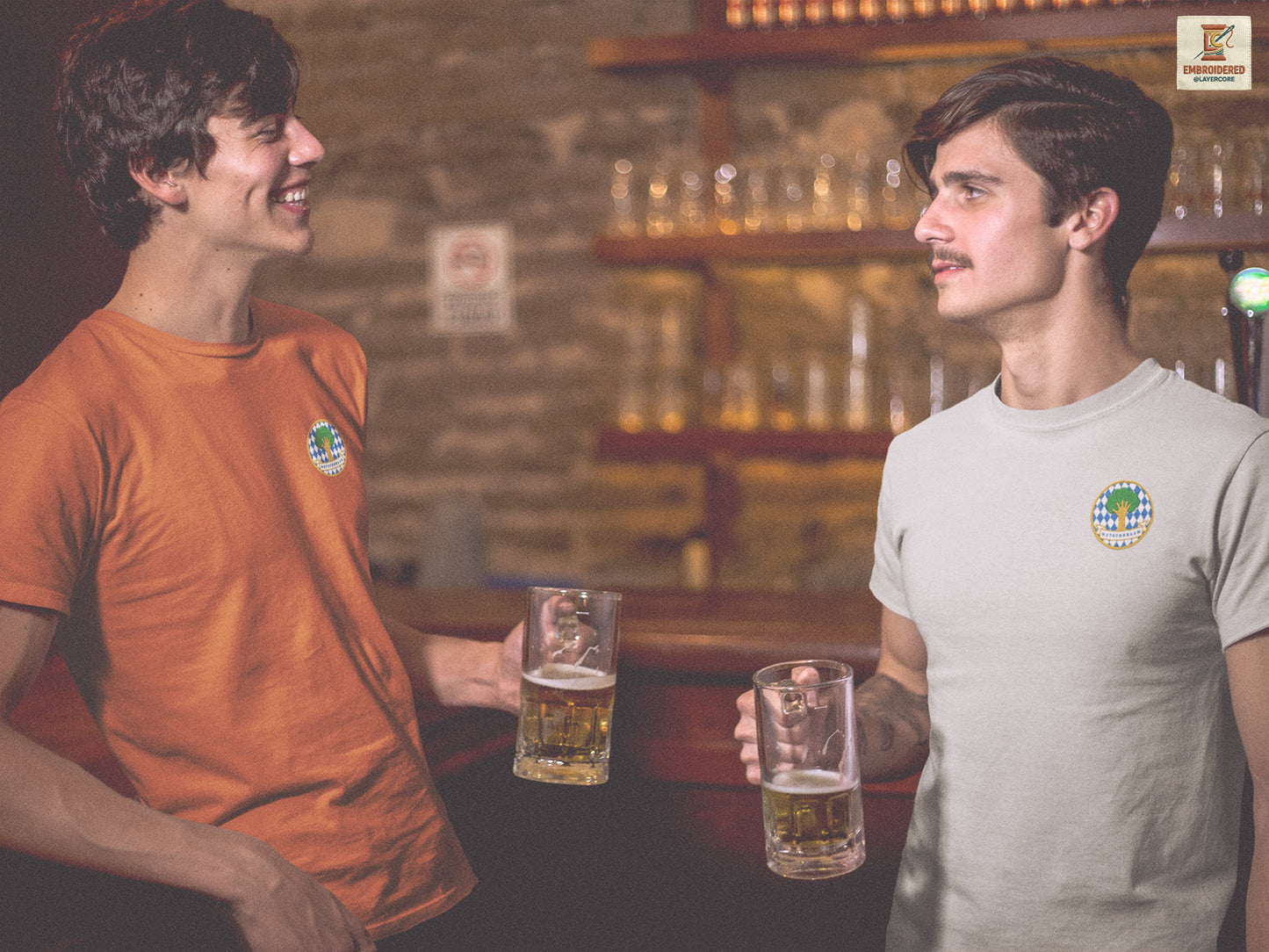 Humorvolles Bayern T-Shirt mit besticktem Watschnbaam Motiv. Das Design kombiniert blau-weiße Rauten, grüne Baumkrone, goldene Konturen und einen bairischen Insider-Spruch. Die Stickerei macht das Shirt hochwertig, textil und besonders passend für Oktoberfest, Volksfest, Heimat-Humor und Mundart-Fans in verschiedenen Farben