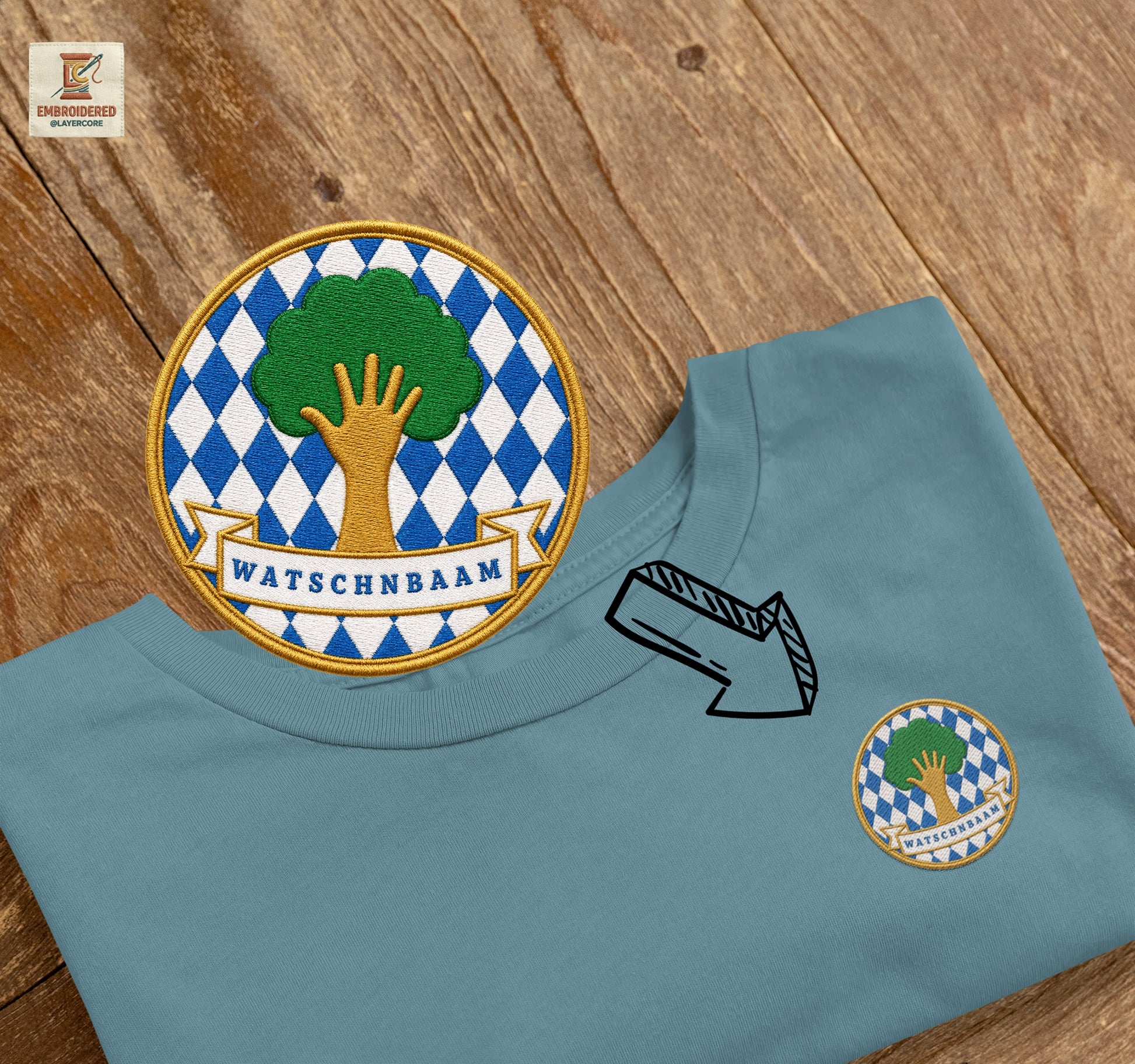 Besticktes Watschnbaam T-Shirt mit Bayern-Rauten, Baum und Hand für bayerischen Dialekt-Humor in teal blau