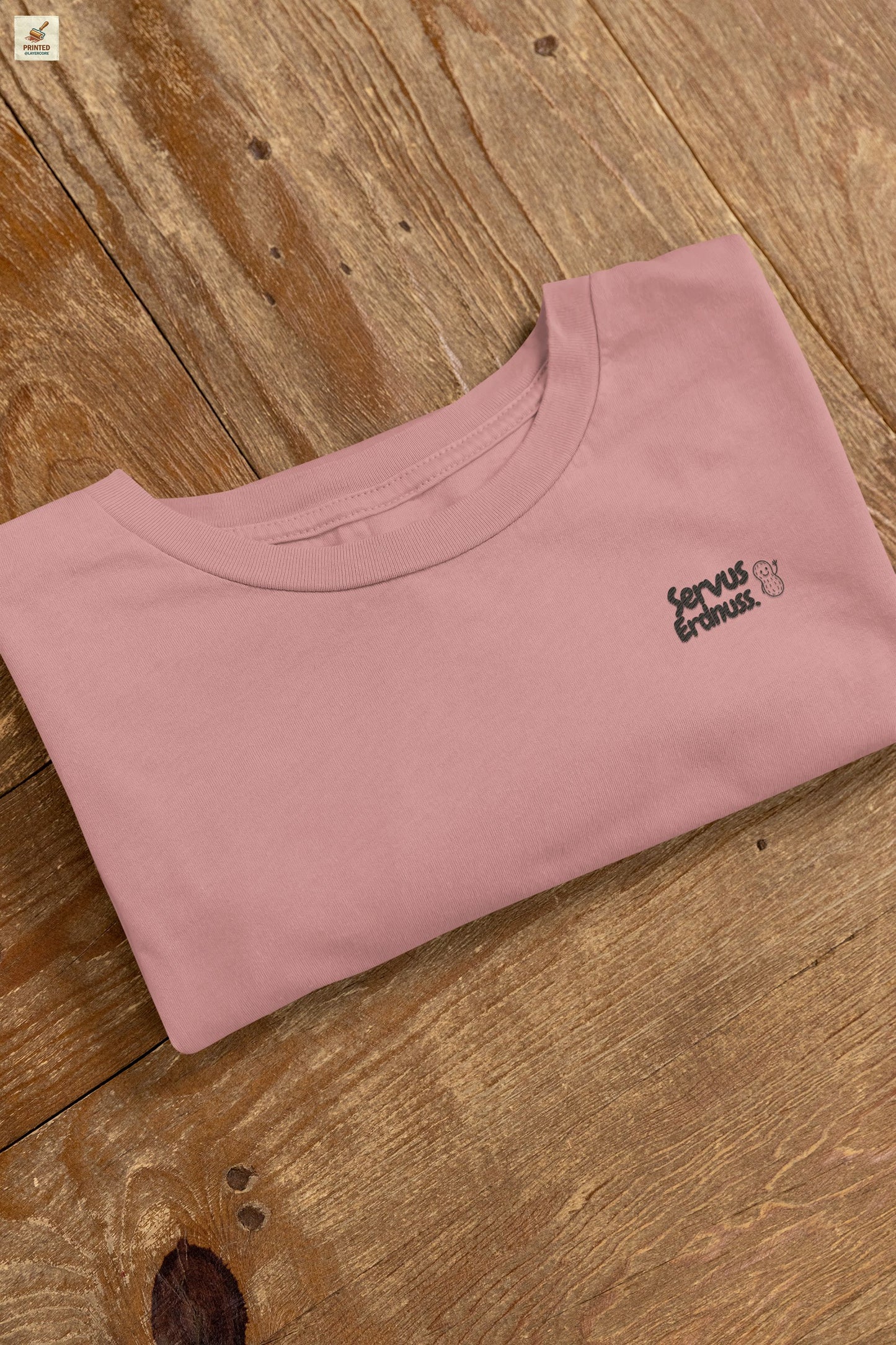 Servus Erdnuss Brustmotiv mit Dialekt-Text und kleiner Erdnussfigur auf heather mauve farbenem Shirt