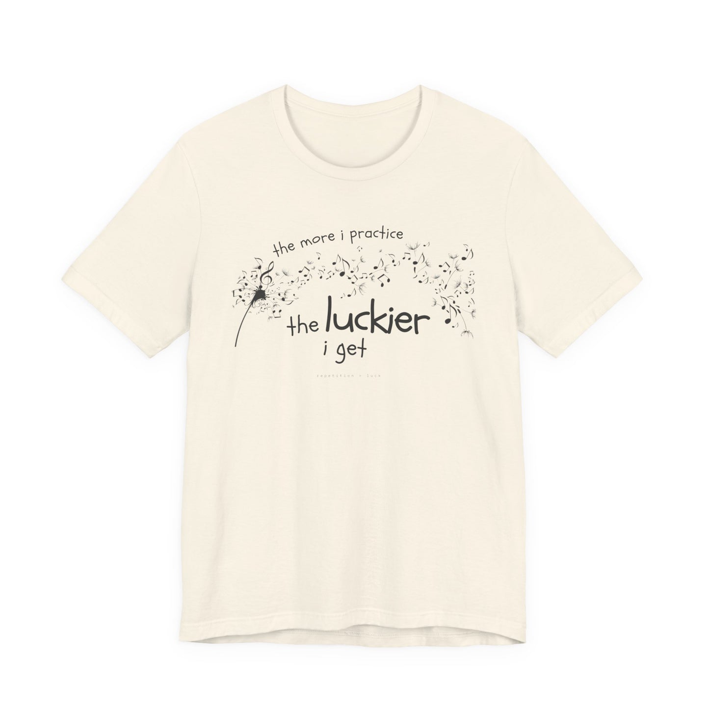 Front view of a natural coloured Bella Canvas t-shirt with a clever music-themed graphic. The design shows a stylized guitar headstock and musical notes above text that reads: ‘The more I practice, the luckier I get.’ Soft 100% cotton shirt perfect for musicians and music teachers.