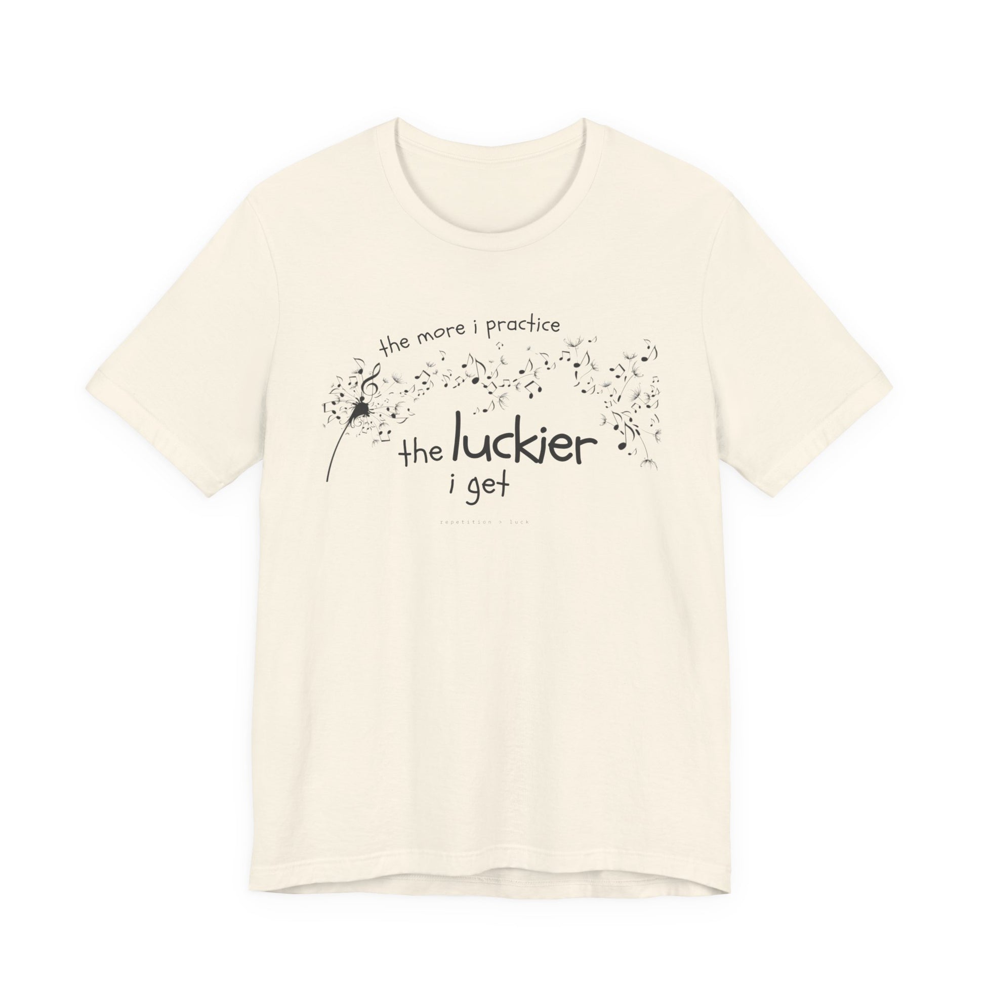 Front view of a natural coloured Bella Canvas t-shirt with a clever music-themed graphic. The design shows a stylized guitar headstock and musical notes above text that reads: ‘The more I practice, the luckier I get.’ Soft 100% cotton shirt perfect for musicians and music teachers.
