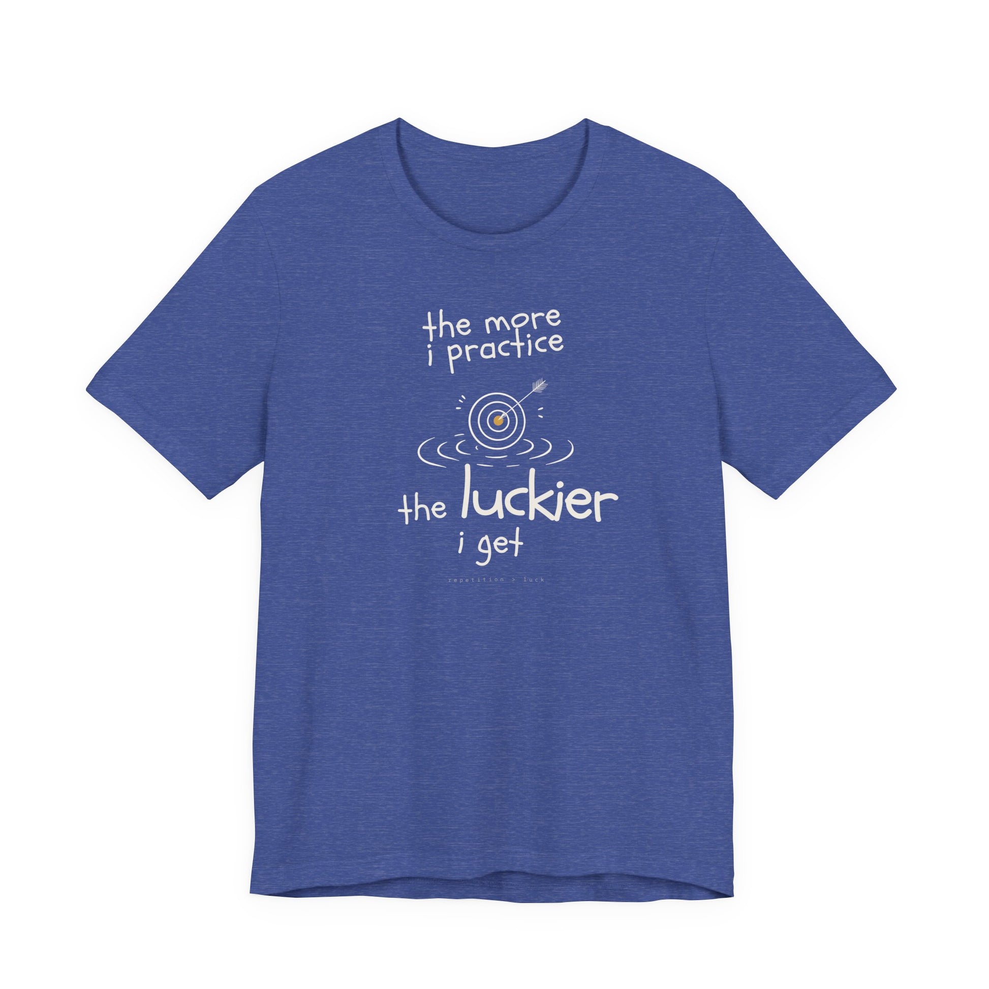 Minimalist motivational T-shirt design shown on a blue shirt: hand-drawn cream lettering reads “the more i practice” above a sketched bullseye with an arrow and small mustard center, ripple lines underneath, then larger text reads “the luckier i get” with tiny mono text below that says “repetition > luck.”